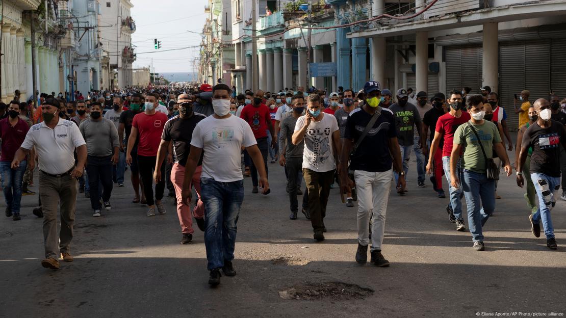 Muitas pessoas caminham por uma rua