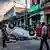 Rua cubana com populares e automóvel emborcado