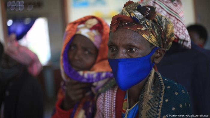 Uganda | Eine Frau warte auf eine COVID-19 Impfung