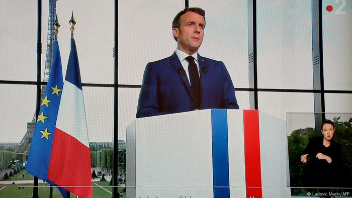 Macron am Rednerpult, neben ihm die französische und die Europafahne, hinter ihm der Eiffelturm