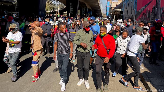 Stick-wielding protesters march through the streets