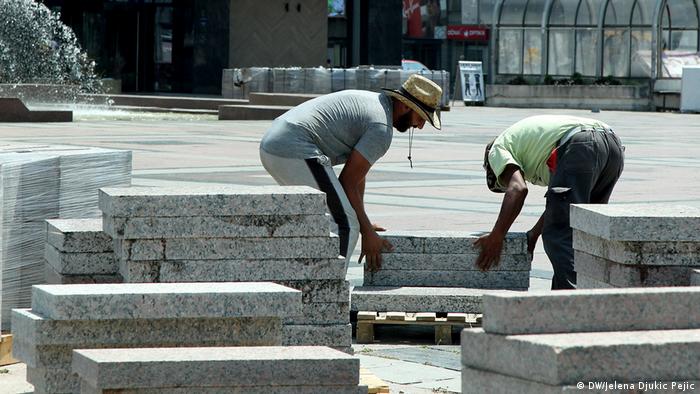 Workers installing concrete slabs at a construction site in Serbia