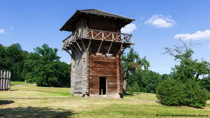Der römische Wachturm beim Kloster Lorch steht auf einer Wiese umgeben von Bäumen.