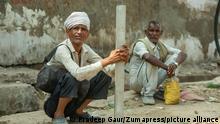 Two men squatting in Uttar Pradesh