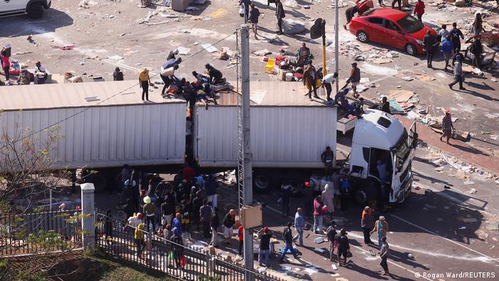 Südafrika , Durban | Plünderungen nahe eines brennenden Warenhauses