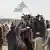 Taliban supporters wave flags as they drive through the Pakistani border town of Chaman