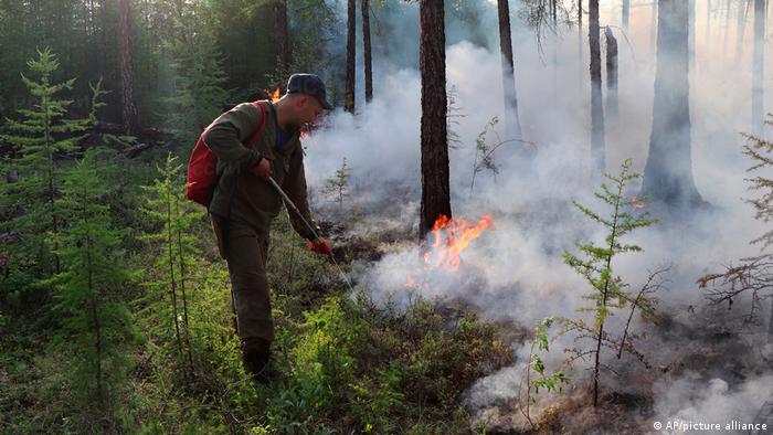 Пожарный бросает огонь в Якутии