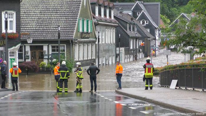Rescue workers stand in front of a flooded street in Solingen. Germany