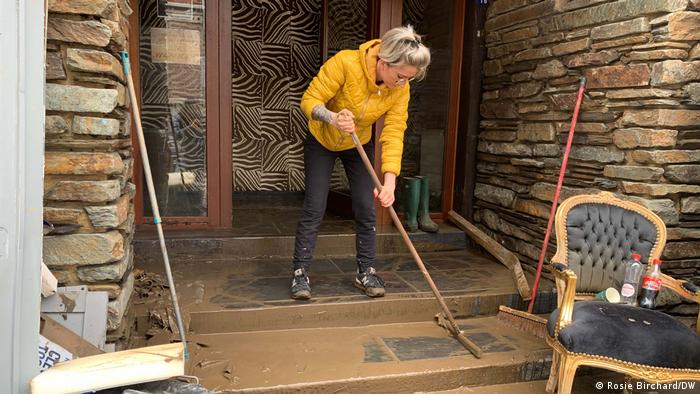 Jennifer Talmas cleaning the mud off her front steps