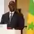 Senegal's President Macky Sall stands in front of the Senegalese flag