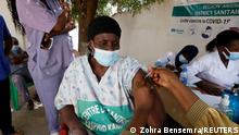 FILE PHOTO: 24.2.2021***
A health worker receives a dose of coronavirus disease (COVID-19) vaccine in Dakar, Senegal February 24, 2021. REUTERS/ Zohra Bensemra/File Photo