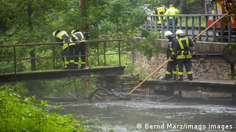Firefighters near a swollen river