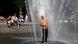 Homem de calça, tênis e sem camisa se banha em um chafariz. Ele ri. Homem de calça, tênis e sem camisa se banha em um chafariz. Ele ri.