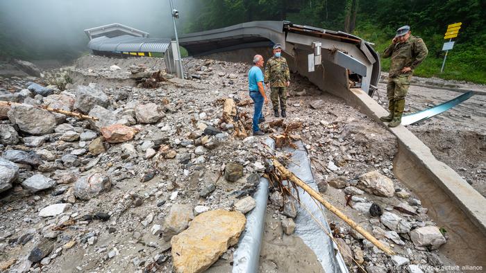 Un résident et deux soldats allemands examinent les dégâts causés par la tempête sur la piste de bobsleigh, de luge et de squelette de Königssee