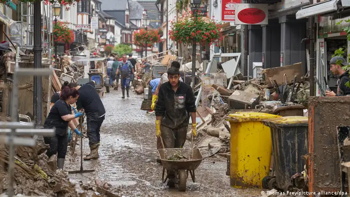 People cleaning the streets of mud and rubble