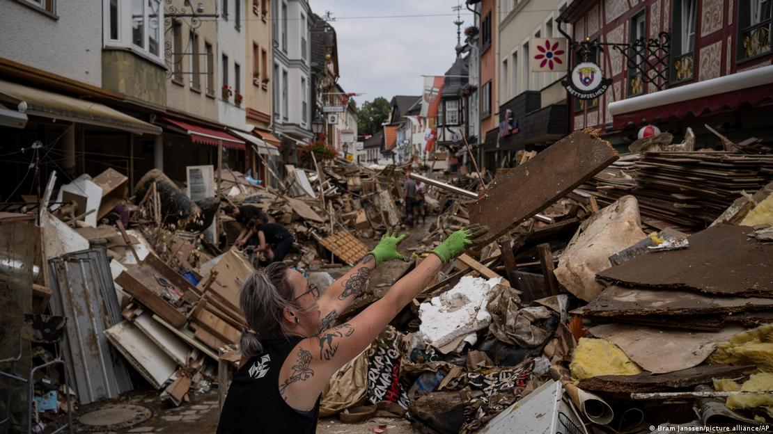 Mulher tenta retirar escombros de uma rua de Bad Neuenahr-Ahrweiler em 19 de julho de 2021