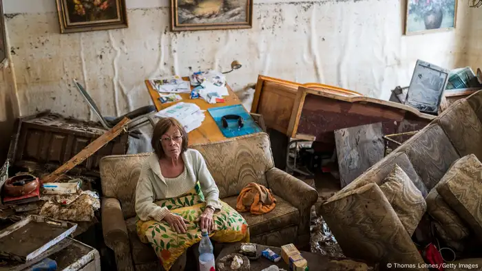 A woman sitting in a destroyed room