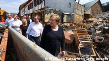 TOPSHOT - German Chancellor Angela Merkel (R) and North Rhine-Westphalia's State Premier, Christian Democratic Union (CDU) leader and CDU's candidate for Chancellery Armin Laschet (2ndR) visit the flood-ravaged city of Iversheim, near Bad Munstereifel, North Rhine-Westphalia state, western Germany, on July 20, 2021. - The German government on July 19, 2021 pledged to improve the country's under-fire warning systems as emergency services continued to search for victims of the worst flooding in living memory, with at least 165 people confirmed dead. (Photo by WOLFGANG RATTAY / POOL / AFP) (Photo by WOLFGANG RATTAY/POOL/AFP via Getty Images)