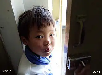 Eight year-old HIV patient Zhang Xiaqing peeks out from the doorway of her home in a village on the outskirts of Beijing Thursday Nov. 1, 2001. Zhang, who has since moved to a hospital in Beijing for treatment, is one of 1000 children in China who have HIV or AIDS. U.N. children's advocates said Wednesday, Nov. 21, 2001, that figure that could grow drastically unless the government exploits its brief opportunity to prevent an epidemic of the disease that is sickening young people across Asia. (AP Photo/Greg Baker)