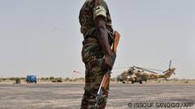 16/06/2016 09:25:42
A Niger army soldier stands guard next to a Niger's Air Force Mi-35P attack helicopter on the tarmac in Diffa, southeastern Niger, during a visit of Niger's Interior Minister on June 16, 2016 following attacks by Nigeria-based Boko Haram fighters in the region. - Interior minister Mohamed Bazoum was paying a visit in Diffa today, after Boko Haram fighters on June 9 attacked a military post in Bosso in Niger's Diffa region, killing 26 soldiers including two from neighbouring Nigeria, in one of its deadliest attacks in Niger. (Photo by ISSOUF SANOGO / AFP)
