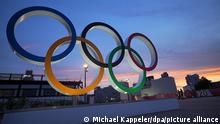 In der Abenddämmerung stehen Olympische Ringe. Die Olympischen Spiele 2020 Tokio finden vom 23.07.2021 bis zum 08.08.2021 statt.