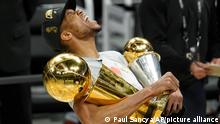 Milwaukee Bucks forward Giannis Antetokounmpo reacts while holding the NBA Championship trophy, left, and Most Valuable Player trophy after defeating the Phoenix Suns in Game 6 of basketball's NBA Finals in Milwaukee, Tuesday, July 20, 2021. The Bucks won 105-98. (AP Photo/Paul Sancya)