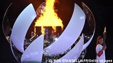 Japan's tennis player Naomi Osaka holds the Olympic torch by the cauldron after lighting the flame of hope in the Olympic Stadium during the opening ceremony of the Tokyo 2020 Olympic Games, in Tokyo, on July 23, 2021. (Photo by Ben STANSALL / AFP) (Photo by BEN STANSALL/AFP via Getty Images)