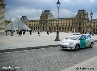 An electric car sits in front of the Louvre in Paris