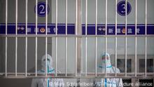 Security officers in protective suits stand at a reception area at the visitors' hall at the Urumqi No. 3 Detention Center in Dabancheng in western China's Xinjiang Uyghur Autonomous Region, on April 23, 2021. Urumqi No. 3, China's largest detention center, is twice the size of Vatican City and has room for at least 10,000 inmates. (AP Photo/Mark Schiefelbein)