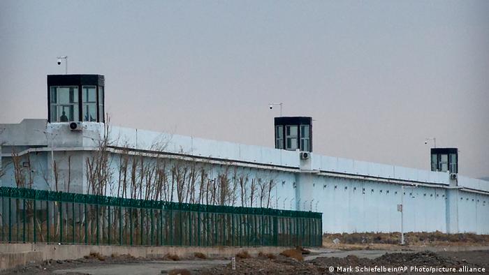 Watchtowers rise above a wall surrounding a detention center in Dabancheng