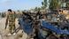 An armed soldier stands next to a site of a bomb blast in Afghanistan An armed soldier stands next to a site of a bomb blast in Afghanistan