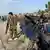 Tentara Afganistan berjaga di depan rongsokan mobil yang hangus karena ledakan bom
