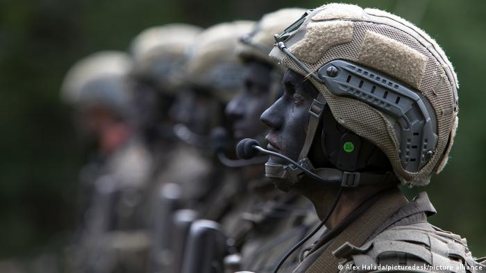 Austrian troops with painted faces stand in formation during border patrol exercises