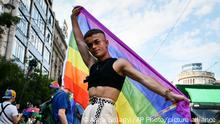 A participant poses with a rainbow flag during a gay pride parade in Budapest, Hungary, Saturday, July 24, 2021. Rising anger over policies of Hungary's right-wing government filled the streets of the country's capital on Saturday as thousands of LGBT activists and supporters marched in the city's Pride parade. (AP Photo/Anna Szilagyi)