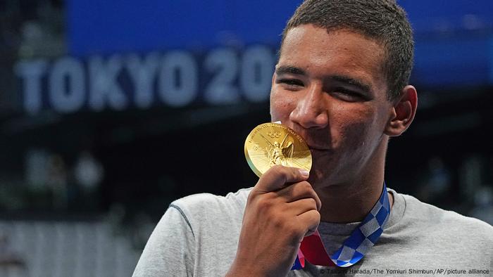 El nadador tuecino Ahmed Hafnaoui besa su medalla arduamente ganada