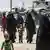 The al-Hol camp in Syria, with veiled women dressed in black full-length clothing and children