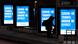 In this Dec. 17, 2020, file photo, a woman waits at a bus stop where pandemic public service signs are displayed in Chicago. In this Dec. 17, 2020, file photo, a woman waits at a bus stop where pandemic public service signs are displayed in Chicago.
