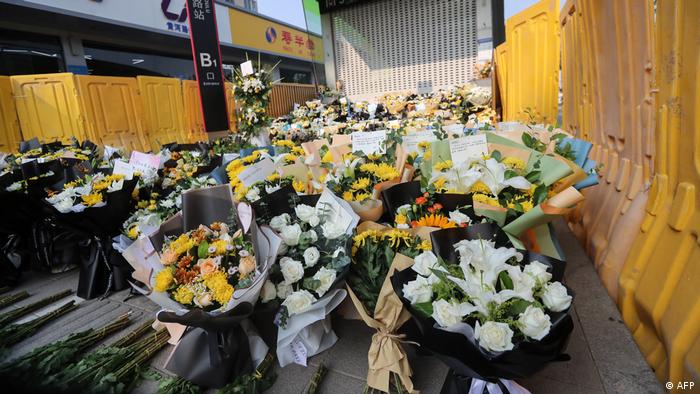 郑州5号线地铁口前 悼念死者鲜花被黄色挡板围住