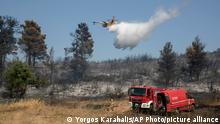 A firefighting airplane drops water during a forest fire at Dionysos northern suburb of Athens, on Tuesday, July 27, 2021. Greek authorities have evacuated several areas north of Athens as a wildfire swept through a hillside forest and threatened homes despite a large operation mounted by firefighters. (AP Photo/Yorgos Karahalis)