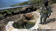 FILE PHOTO: A policeman stands next to a well where minerals taken from illegal gold mines are washed in Buritica, Colombia April 20, 2021. Picture taken April 20, 2021. REUTERS/Luisa Gonzalez/File Photo