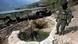 A policeman stands next to a well where minerals taken from illegal gold mines are washed in Buritica, Colombia A policeman stands next to a well where minerals taken from illegal gold mines are washed in Buritica, Colombia
