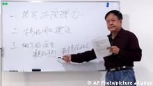 In this Oct. 5, 2020, photo provided by the Legal Team of Dawu Group, Sun Dawu stands at a whiteboard at a hospital in Baoding in northern China's Hebei Province. A prominent Chinese pig farmer who was detained after praising lawyers during a crackdown on legal activists by President Xi Jinping's government has been sentenced to 18 years in prison on charges of organizing an attack on officials and other offenses. The board reads implement the concept of running the hospital, do a good job in team building, be a good doctor who is a good doctor, a responsible person. (Legal Team of Dawu Group via AP)