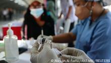 A healthcare worker prepares a dose of China's Sinovac Biotech vaccine against the coronavirus disease (COVID-19) during a mass vaccination program at a train station, as cases surge in Jakarta, Indonesia, July 28, 2021. REUTERS/Ajeng Dinar Ulfiana