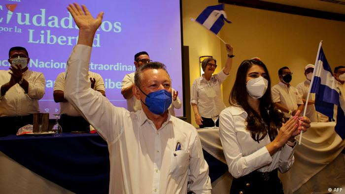 Sobalvarro waves and Quezada holds the Nicaraguan flag during their nomination announcement 