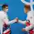 Two athletes of Team Great Britain shaking hands during a medal ceremony at the Tokyo Olympics