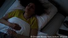 ILLUSTRATION - Eine Frau liegt am 14.11.2018 in einer Wohnung in Hamburg in einem Bett und schlaeft (gestellte Szene). Foto: Christin Klose || Modellfreigabe vorhanden