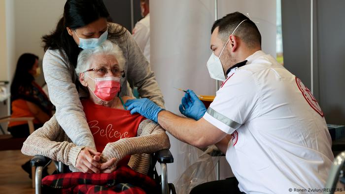 An elderly woman in a wheelchair receives her third coronavirus vaccination in Netanya, Israel