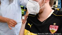 A supporter of German first division Bundesliga football team VfB Stuttgart gets his vaccination with Johnson & Johnson at a mobile vaccination center near the Mercedes-Benz arena in Stuttgart, southern Germany, on July 31, 2021 ahead of the football test match VfB Stuttgart v FC Barcelona. (Photo by THOMAS KIENZLE / AFP) (Photo by THOMAS KIENZLE/AFP /AFP via Getty Images)