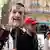 متظاهر في باريس يحمل قناعاً للرئيس الفرنسي إيمانويل ماكرون
