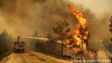 A firefighter extinguishes a forest fire near the town of Manavgat, east of the resort city of Antalya, Turkey, July 30, 2021. REUTERS/Kaan Soyturk